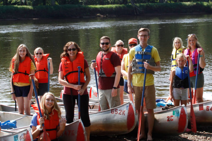 a group of people standing next to a body of water